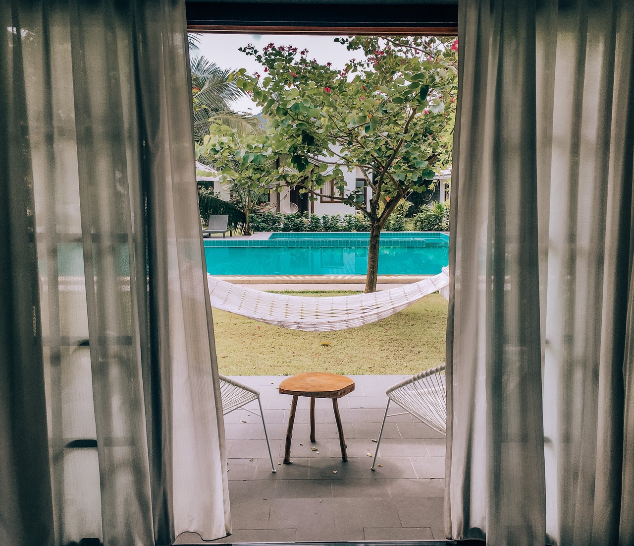 fenêtre ouverte sur un jardin avec piscine